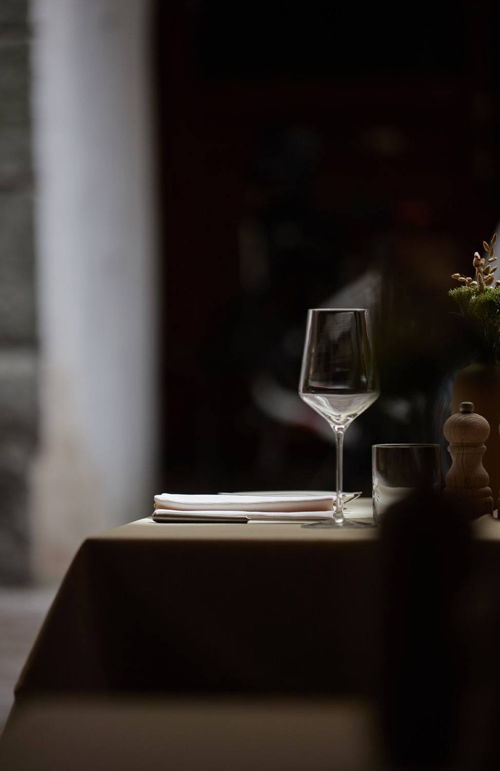 Atmospheric photo of a wine glass on a discreetly set table